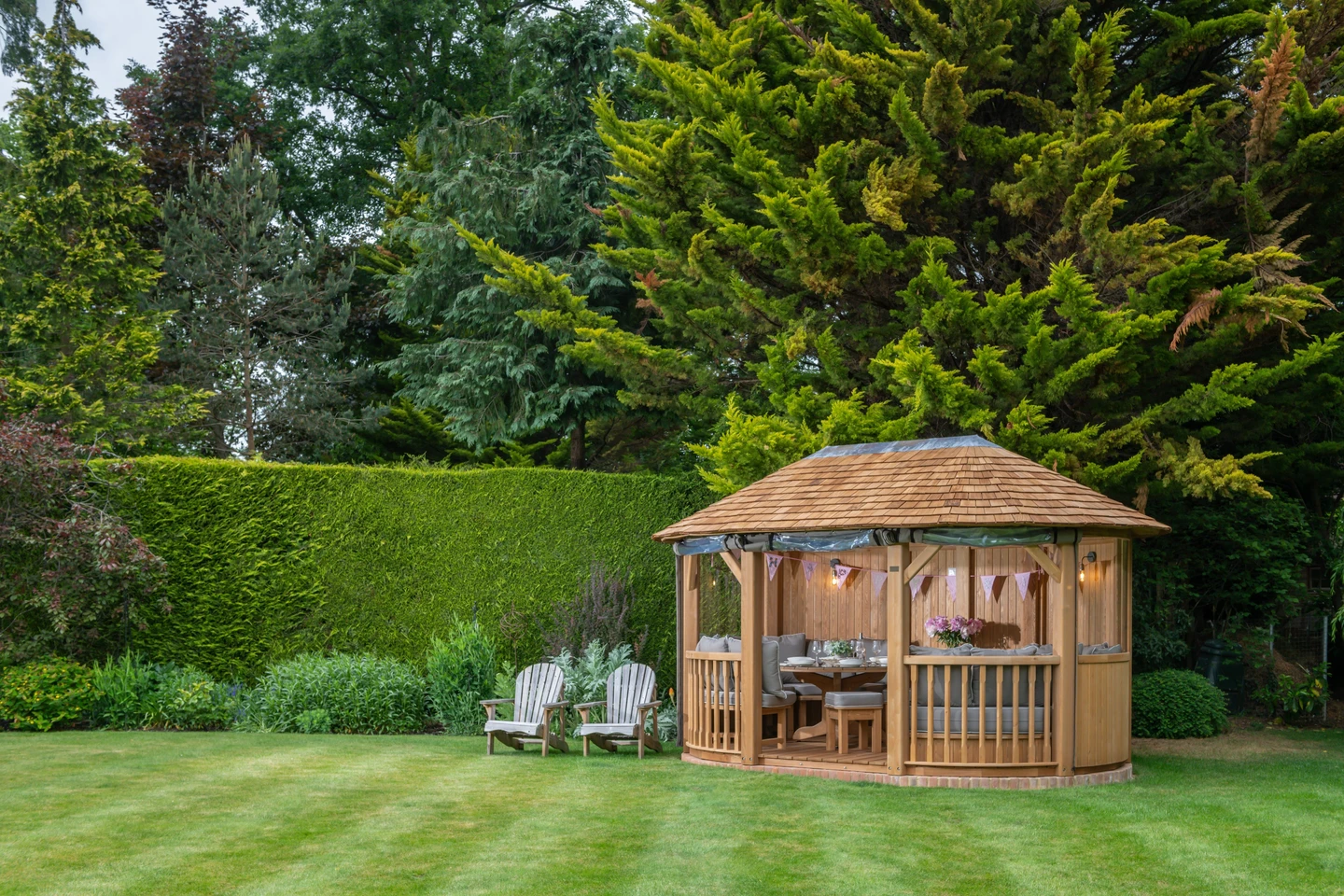 Luxury wooden gazebo with cedar shingle roof and festoon lighting